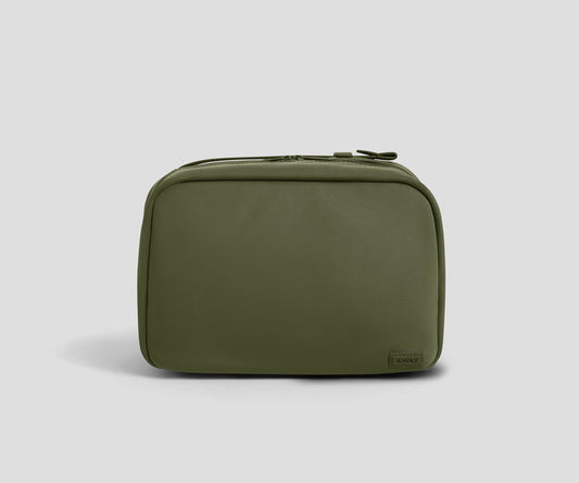 An olive green zippered toiletry bag with a small dark brand tag on the bottom right corner, photographed on a neutral light gray background.