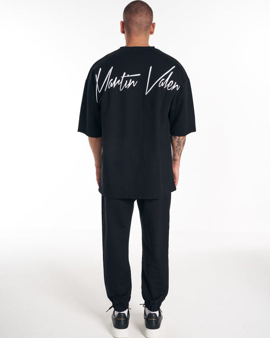 Martin Valen men's oversized black tracksuit top, rear view with large white logo embroidered across the upper back