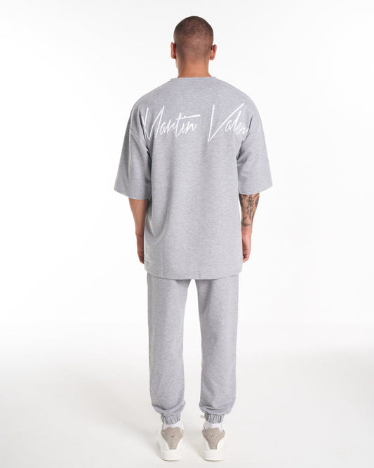 Martin Valen light grey men's oversize tracksuit seen from back, white script logo across upper back