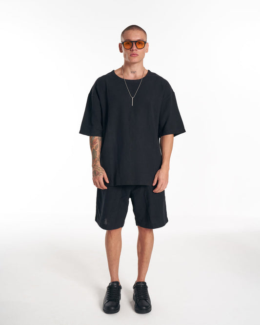 Martin Valen men’s black twill short tracksuit, full-frontal view on model showing side pocket detail