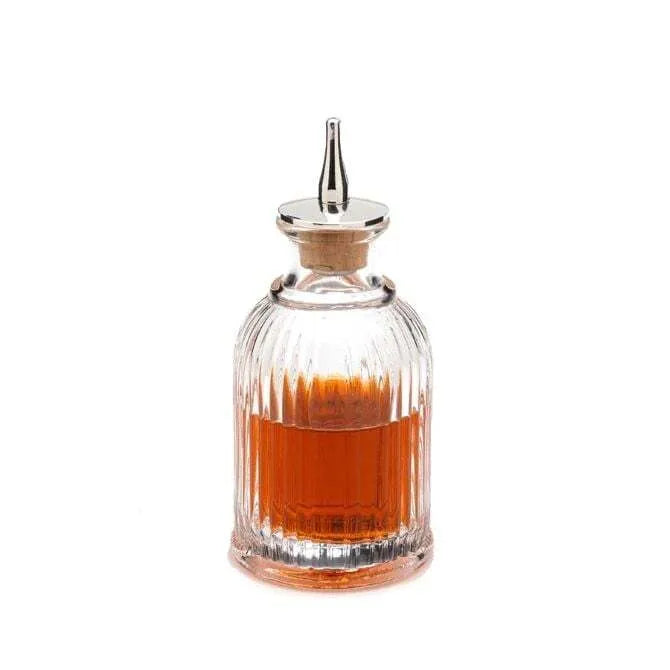Mercer Bitter / Dash Bottle shown filled with bitters liquid shot on whit silo background.