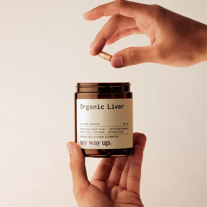 Hand holding a jar labeled 'Organic Liver' with a beige background