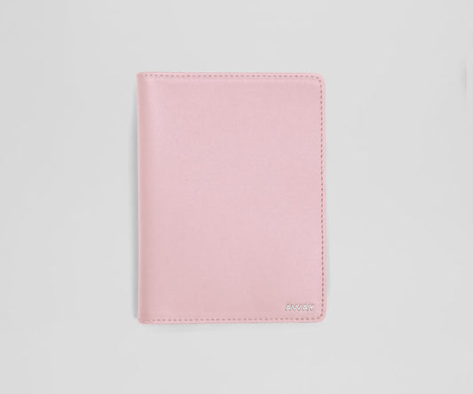 Pink leather passport sleeve on a light gray background