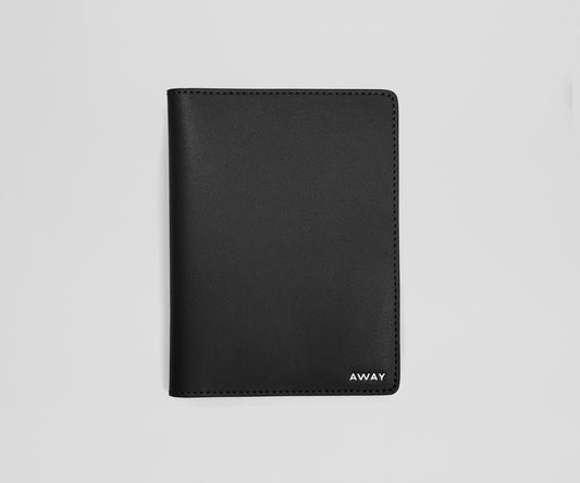Black leather passport holder with 'AWAY' branding on a light gray background