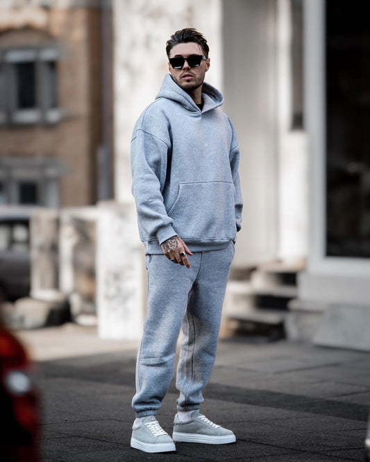 Martin Valen Regalia Crown oversized grey hoodie and joggers, three-quarter outdoor view, small crown logo on chest visible