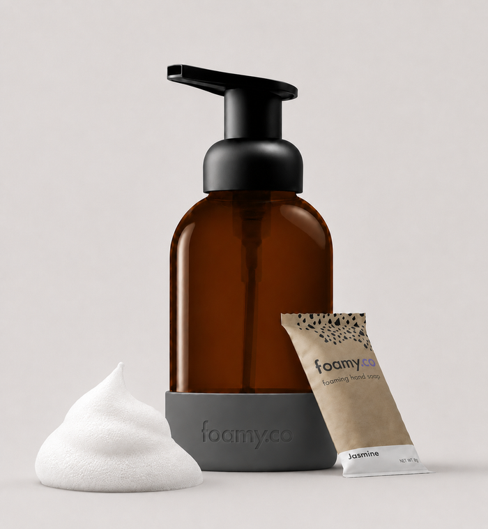 The Cloud Foam Kit featuring an amber glass bottle, foaming hand soap, and a jasmine soap pouch.
