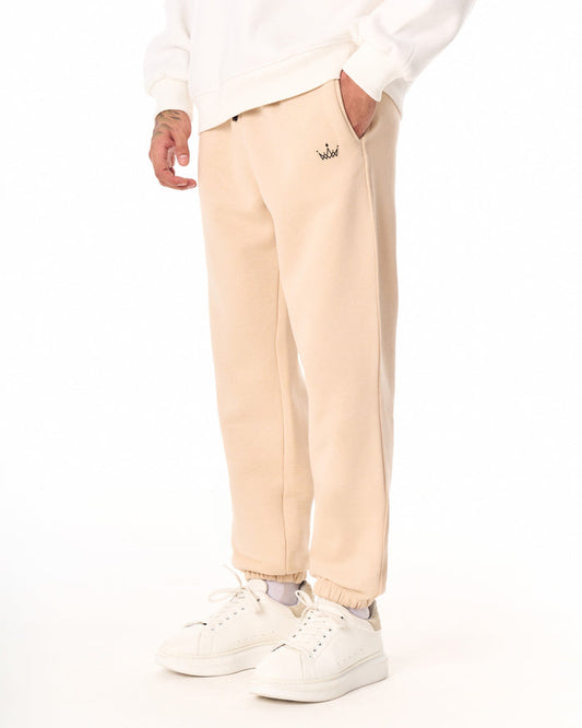 Martin Valen oversized beige jogger, frontal thigh view showing black crown logo near the pocket