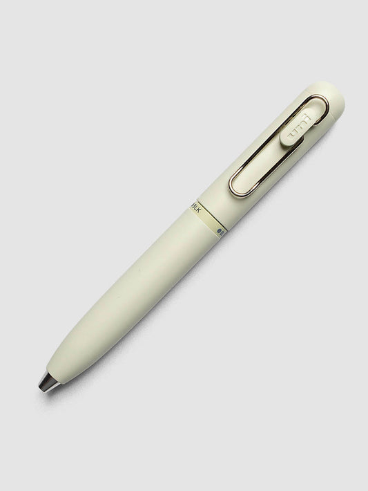 Uni-ball One 3-Color Ballpoint Pen in pale sage green laid diagonally showing clip and BLK color indicator
